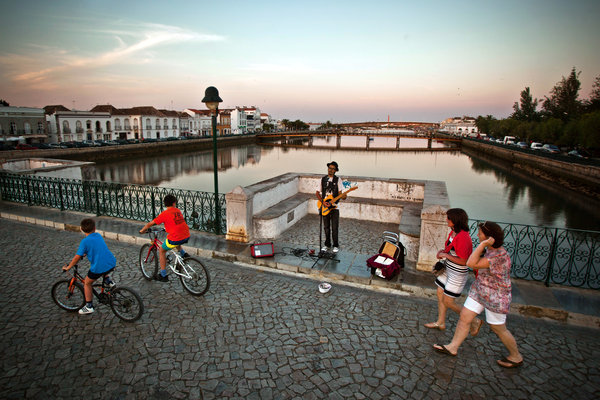 Artist playing music at the Roman Bridge, Tavira, Algarve, Portugal
